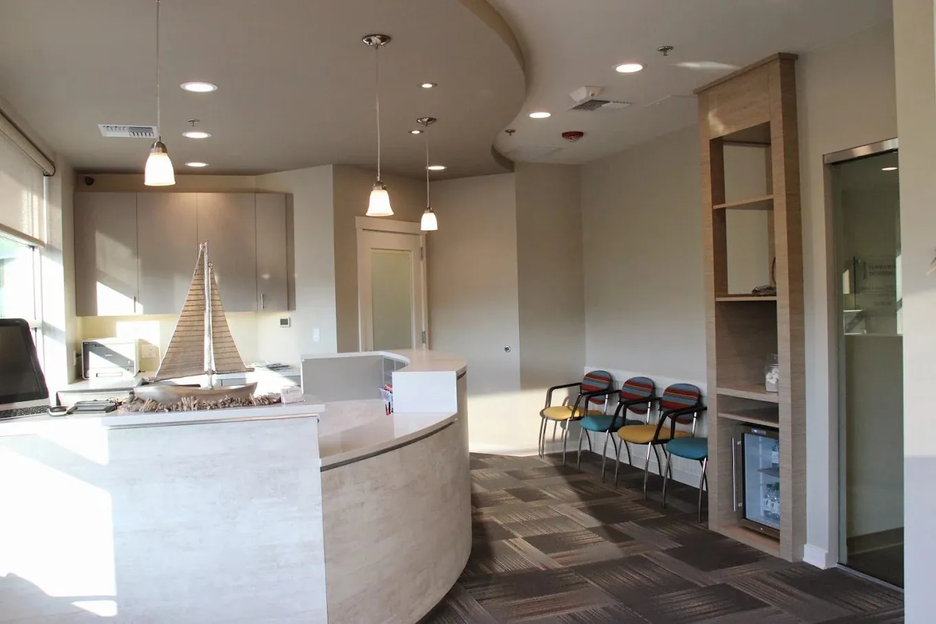 Our bright front desk and waiting area with a sailboat display